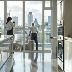 two professional female tenancy cleaners performing a full move-out cleaning service inside a modern London apartment